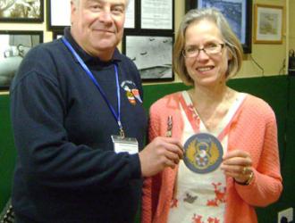 Lauri Atkins, who has compiled a list of all the USAAF memorials in Suffolk and Norfolk, hands over a copy of the DVD to volunteer John