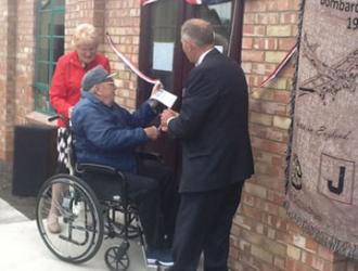 390th Veteran Leroy cutting the tape  to open the new building